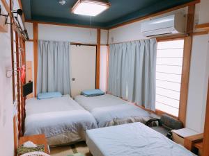 A bed or beds in a room at Ryokoheya Hankyukan