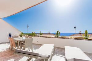 アデへにある1713 SUNSET ocean view, terrace,heated poolの海を望むパティオ(テーブル、椅子付)