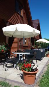 a patio with a table and chairs and an umbrella at Diament Rogowo in Rogowo