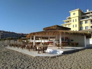 a restaurant with tables and chairs on the beach at Nestinarka Complex - Emili Apartment in Tsarevo