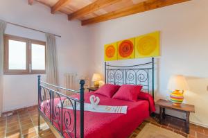 a bedroom with a bed with red sheets and red pillows at Sa Caseta (Caseta) in Inca