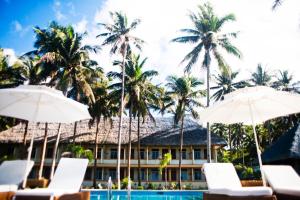 a resort with a pool and palm trees and umbrellas at Vitton Resort in Donsol