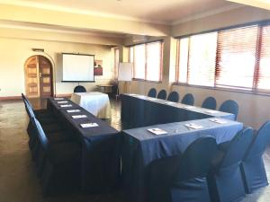 a meeting room with tables and chairs and a screen at Lido Hotel in Johannesburg +66 photos