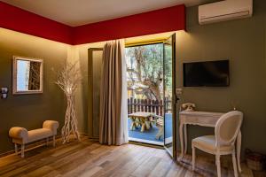 - un salon avec un bureau et une porte coulissante en verre dans l'établissement Petani Bay Hotel - Adults Only, à Vóvikes