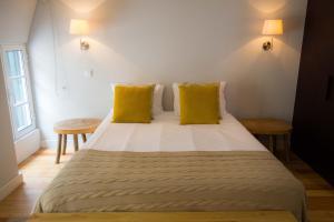 een slaapkamer met een groot bed met gele kussens bij Apartamentos Santa Maria by Heart of Funchal in Funchal