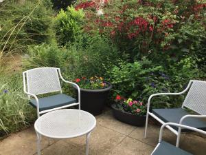 three chairs and a table in front of a garden at Ingleneuk Bed and Breakfast in Edinburgh