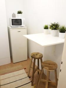 a kitchen with a white counter and two stools at Studio Old Center in Bucharest