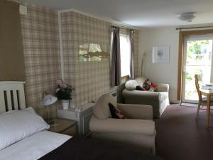 a bedroom with a bed and a couch and a chair at Ingleneuk Bed and Breakfast in Edinburgh