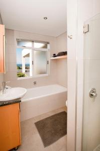 a bathroom with a bath tub and a sink at Palamos on Sea in St Francis Bay