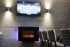 a living room with a fireplace and a tv on a wall at Station Hotel Stonehaven in Stonehaven