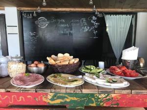 una mesa con platos de comida y una pizarra en Hotel Tihiat Kat en Apriltsi