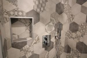 a bathroom with a mirror and a tiled wall at Del Prado in Riva Ligure