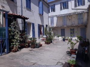 einen Innenhof mit Topfpflanzen vor einem Gebäude in der Unterkunft Le Tivoli in Cannes