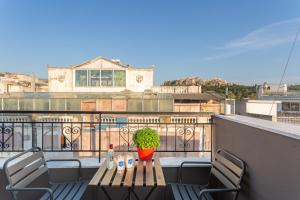 a table and chairs on a balcony with a view at Downtown Boutique Apartments Acropolis View in Athens