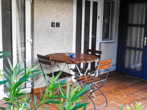 a wooden table and two chairs on a porch at Lake Vendégház in Alsóörs
