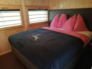 Schlafzimmer mit einem Bett mit roten Polyka-Punktkissen in der Unterkunft Camping Gravatscha in Samedan