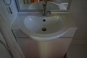 La salle de bains est pourvue d'un lavabo blanc et d'un miroir. dans l'établissement Na Rebri, à Luče