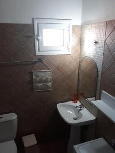 a bathroom with a sink and a toilet and a window at Filoxenia Apartments in Skala Sotiros +19 photos