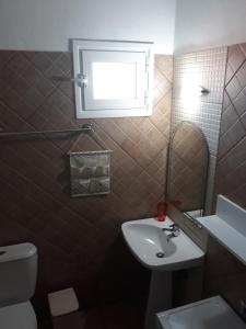 スカラ・ソティロスにあるFiloxenia Apartmentsのバスルーム(洗面台、トイレ付)、窓が備わります。