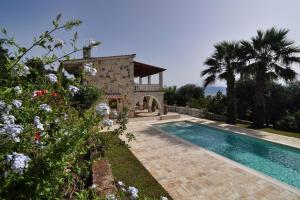 une villa avec une piscine et une maison dans l'établissement Ionian Garden Villas - Villa Pietra, à Benitses