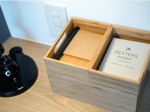 a wooden box with a pen in it on a table at Resters Bed&Co. in Kumamoto