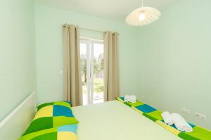 a white bedroom with a bed and a window at Apartments & Rooms Tapera in Dubrovnik
