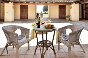 - une table avec deux chaises et un verre de vin dans l'établissement Villa Giannina, à Ispica
