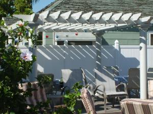 une pergola blanche avec des chaises et des tables sur une terrasse dans l'établissement Sunnyside Inn Bed &Breakfast, à Sunnyside