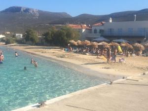 a group of people in the water on a beach at Eugenia travasarou sea view appartments in Diakofti