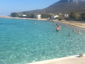 a group of people in the water at a beach at Eugenia travasarou sea view appartments in Diakofti