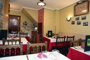 a restaurant with tables and chairs with red table cloth at Hotel Restaurante Oviedo in Luarca