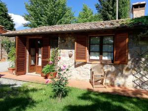 a small stone house with a chair in the yard at Podere Sionne in Chiusi