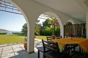 a patio with a table and a view of the ocean at Lagonisi Beach Resort in Ormos Panagias
