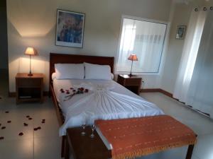 a bedroom with a large bed with flowers on it at Ferradura Parque Pousada in Búzios