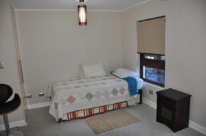 a small bedroom with a bed and a window at Andes Chillan Paraíso en la Montaña in Nevados de Chillan