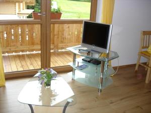 a living room with a television on a glass table at Ferienhaus Beyer in Unterwössen