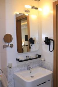 a bathroom with a sink and a mirror at Momona Hotel in Addis Ababa
