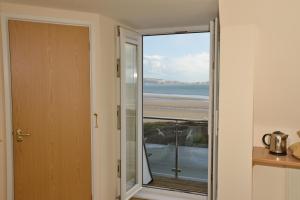 a door to a balcony with a view of the beach at The Penellen guest accommodation room only in Hayle