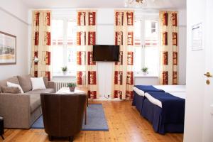 a living room with a couch and a tv at Hotel Emma in Östersund