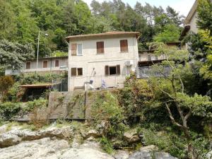 a house on the side of a hill with trees at The River House in Agaggio Inferiore