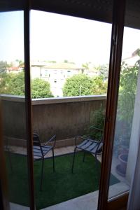 uma varanda com 2 cadeiras e vista para um quintal em B&B Villa Lattes em Vicenza