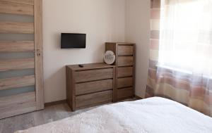 シュクラルスカ・ポレンバにあるApartament NR 5のベッドルーム1室(ベッド1台、ドレッサー、テレビ付)