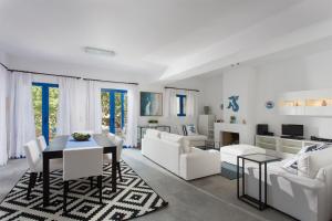 a living room with white furniture and a table at Aneli Luxury Villas-Villa Aegina in Aegina Town