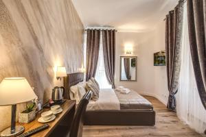 ローマにあるRiver Luxury Suitesのベッドルーム1室(ベッド1台、デスク、窓付)