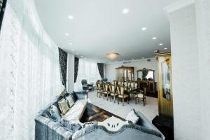 a living room with a couch and a dining room at Hotel Arai Plaza in Taraz