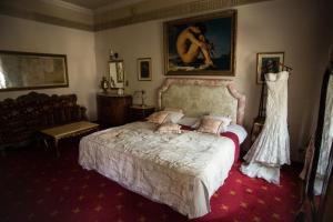 een slaapkamer met een bed en een portret van een vrouw bij Hotel Ambasada Bolesławiec in Bolesławiec