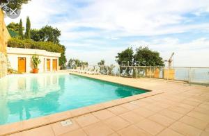 a swimming pool with blue water in a yard at La terrazza di monaco in Cap d'Ail