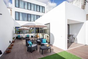 Praia de Santos, Exclusive Villa, Açores في بونتا ديلغادا: سطح مفتوح مع كراسي وطاولات على مبنى