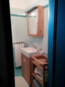 y baño con lavabo y espejo. en B&b Zita, en Levico Terme