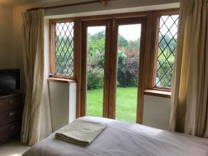 a bedroom with a bed and a large window at Hurst Hill in Dunsfold